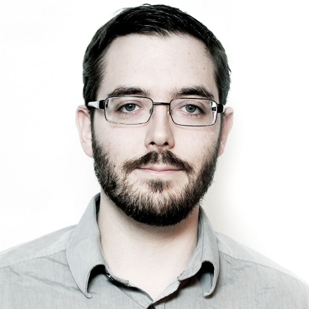 image of Justin MacNeil, a bearded middle-aged man with glasses.